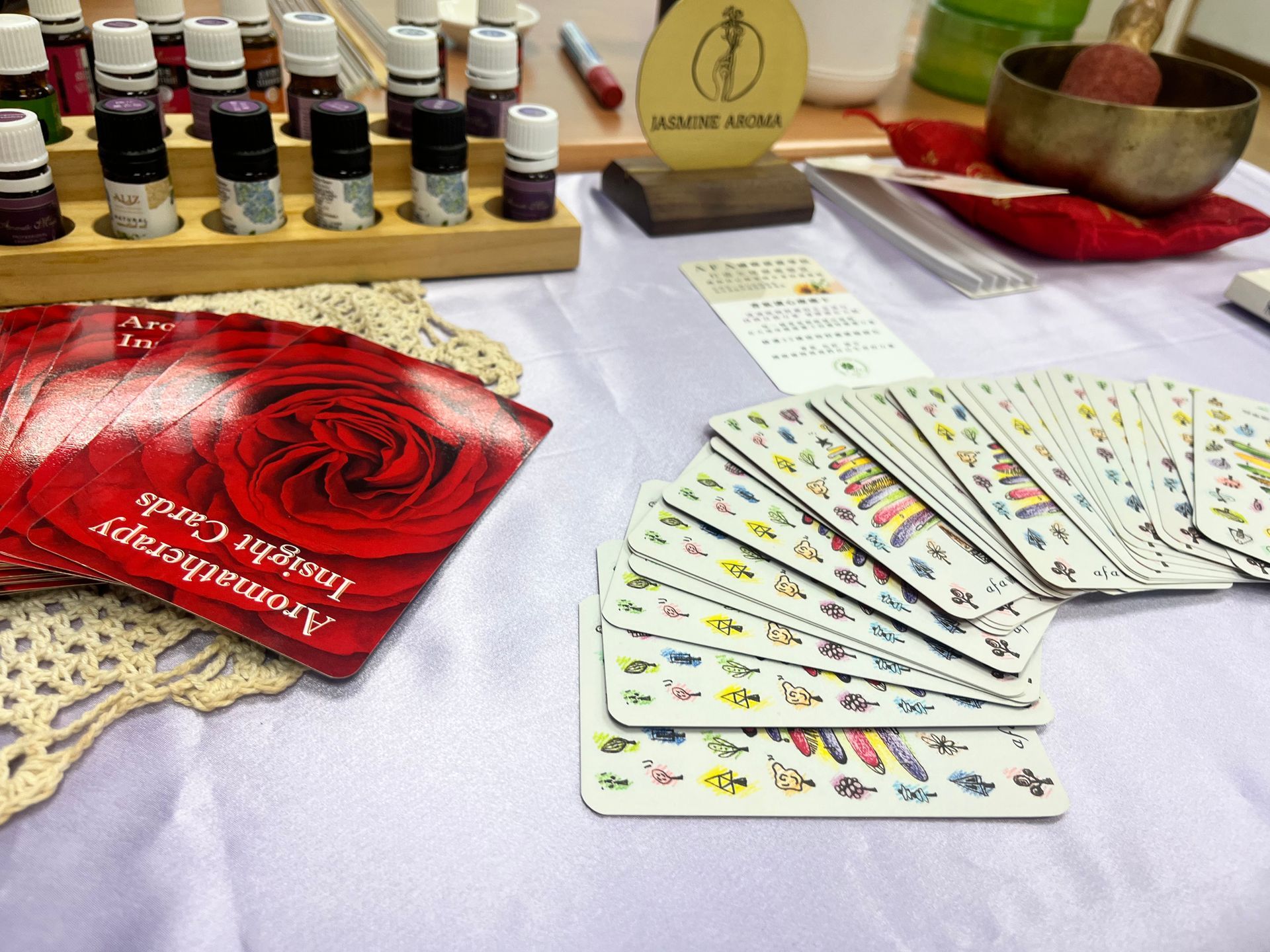 桌上擺放著塔羅牌、精油和頌缽。