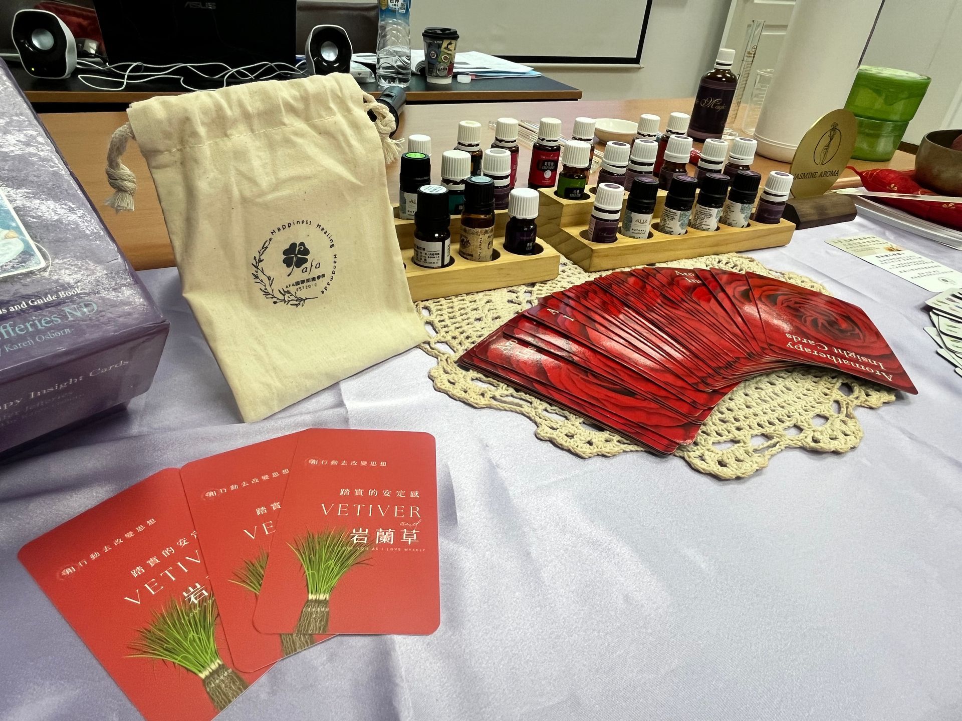 桌子上擺放著精油瓶、紅色卡片、束口袋和裝飾桌布。