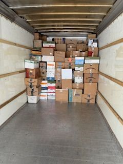 Loaded moving truck with stacked cardboard boxes filling the back cargo area