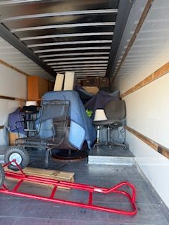 Packed moving truck with furniture and a red dolly on the floor