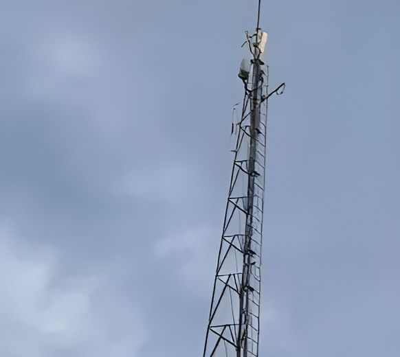 A Very Tall Antenna Tower Against A Cloudy Sky — Outback Internet & Comms In Ciccone, NT