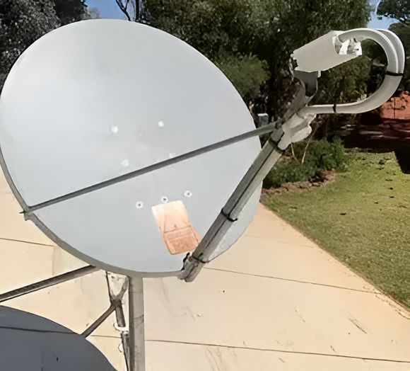 A Large White Satellite Dish Is Sitting On A Sidewalk — Outback Internet & Comms In Ciccone, NT