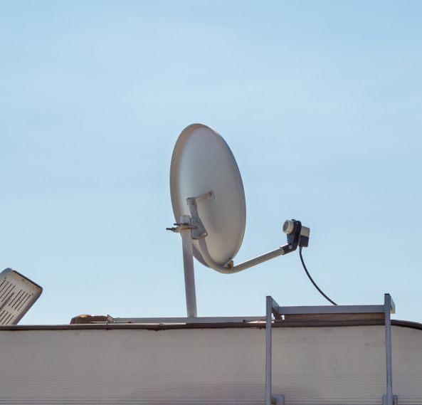 A Satellite Dish On Top Of A Building With A Blue Sky In The Background — Outback Internet & Comms In Ciccone, NT