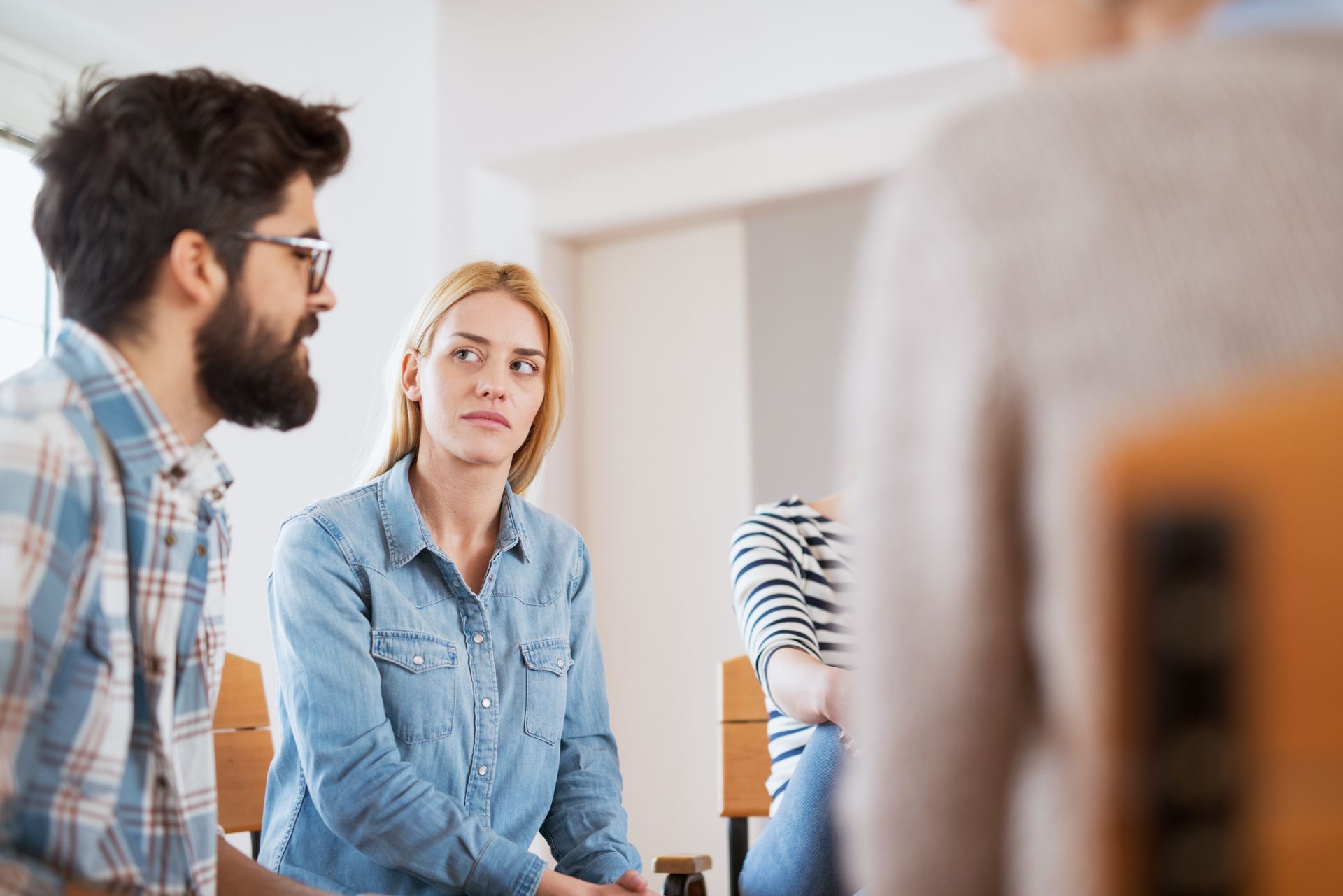 A group of people are sitting around a table talking to each other.