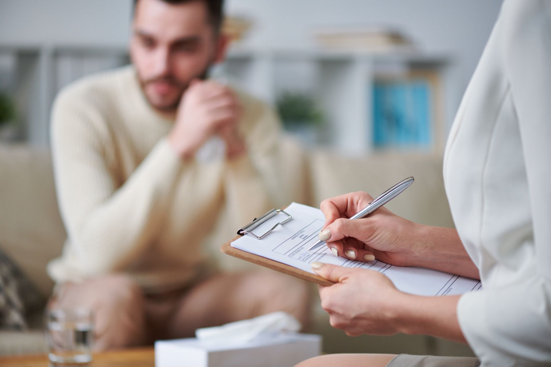 A woman is holding a clipboard in front of a man.