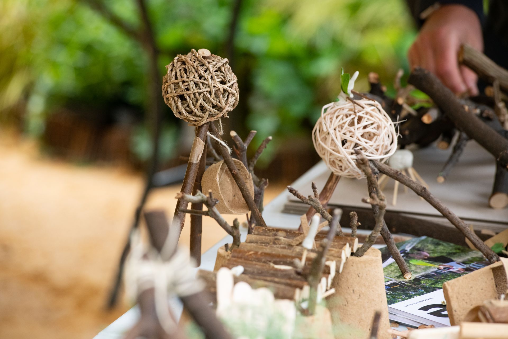 Wooden craft structures with woven spheres and stick elements on a table.