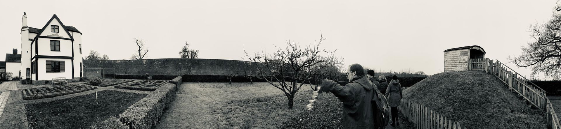 A black and white photo of a house with a garden.