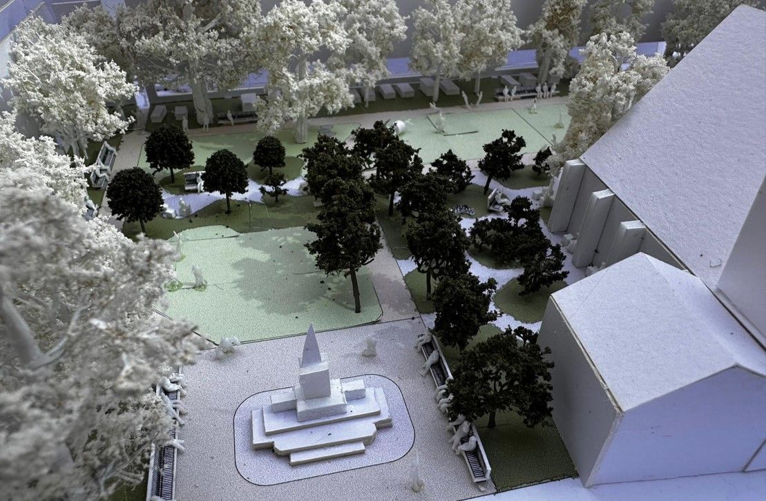Architectural model, public square with trees, monument, and buildings.