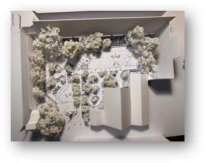 Architectural model of a building with trees, a courtyard, and surrounding structures.