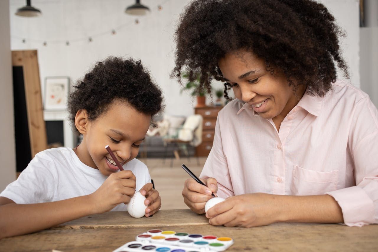 Montessori parent and child painting together, sharing connection, joy, and quality time through play.