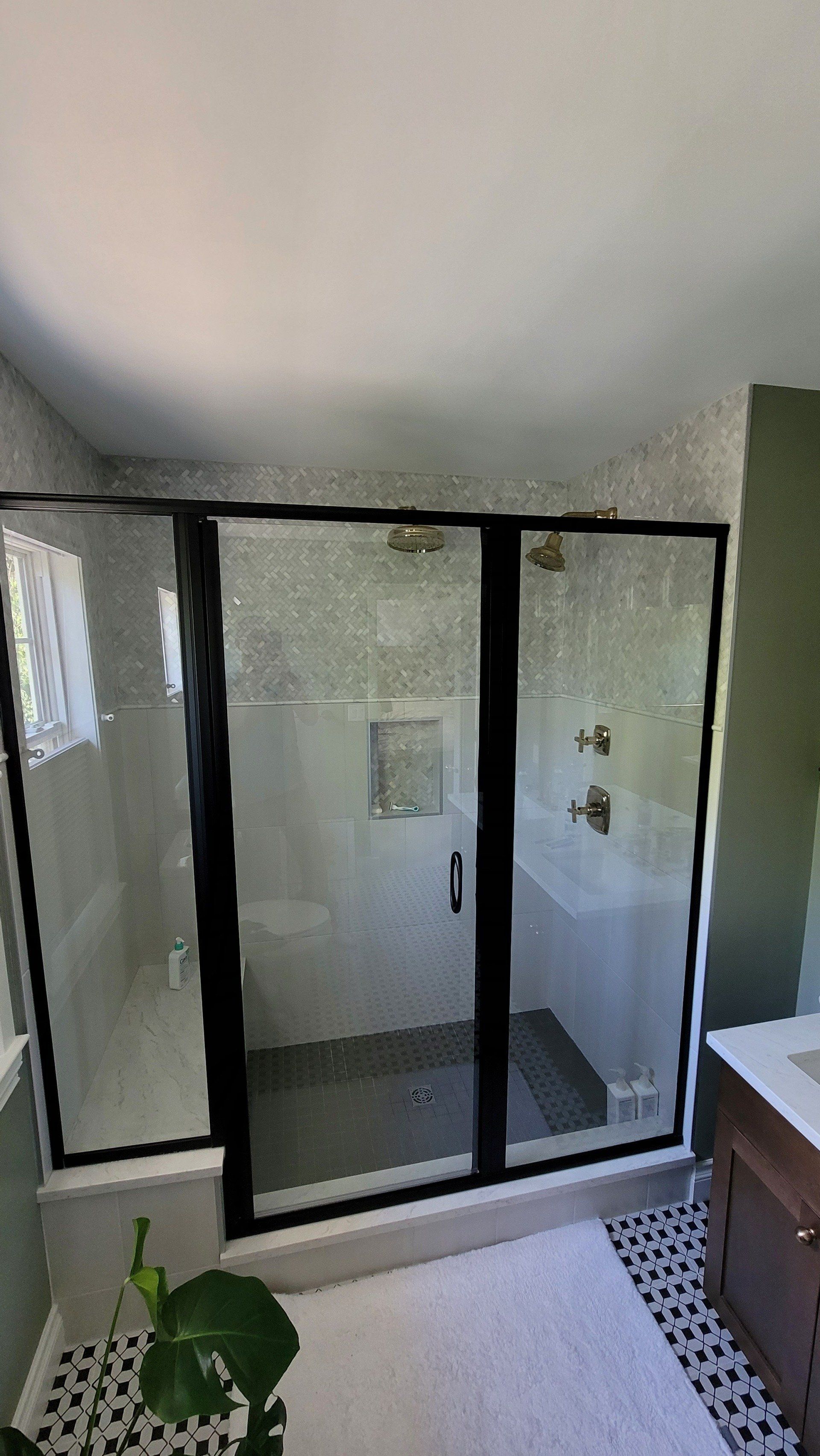 A bathroom with a walk in shower and a sink.