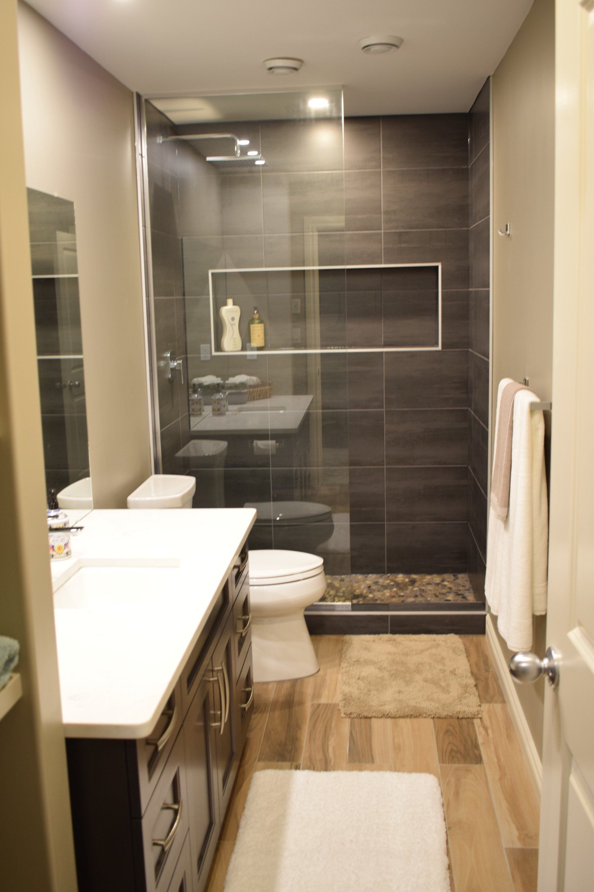 A bathroom with a toilet , sink , and walk in shower.