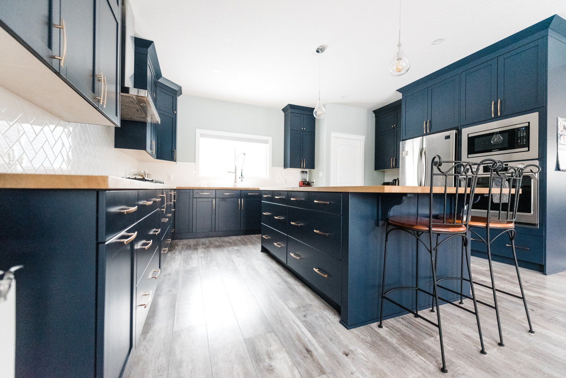 A kitchen with blue cabinets and stainless steel appliances