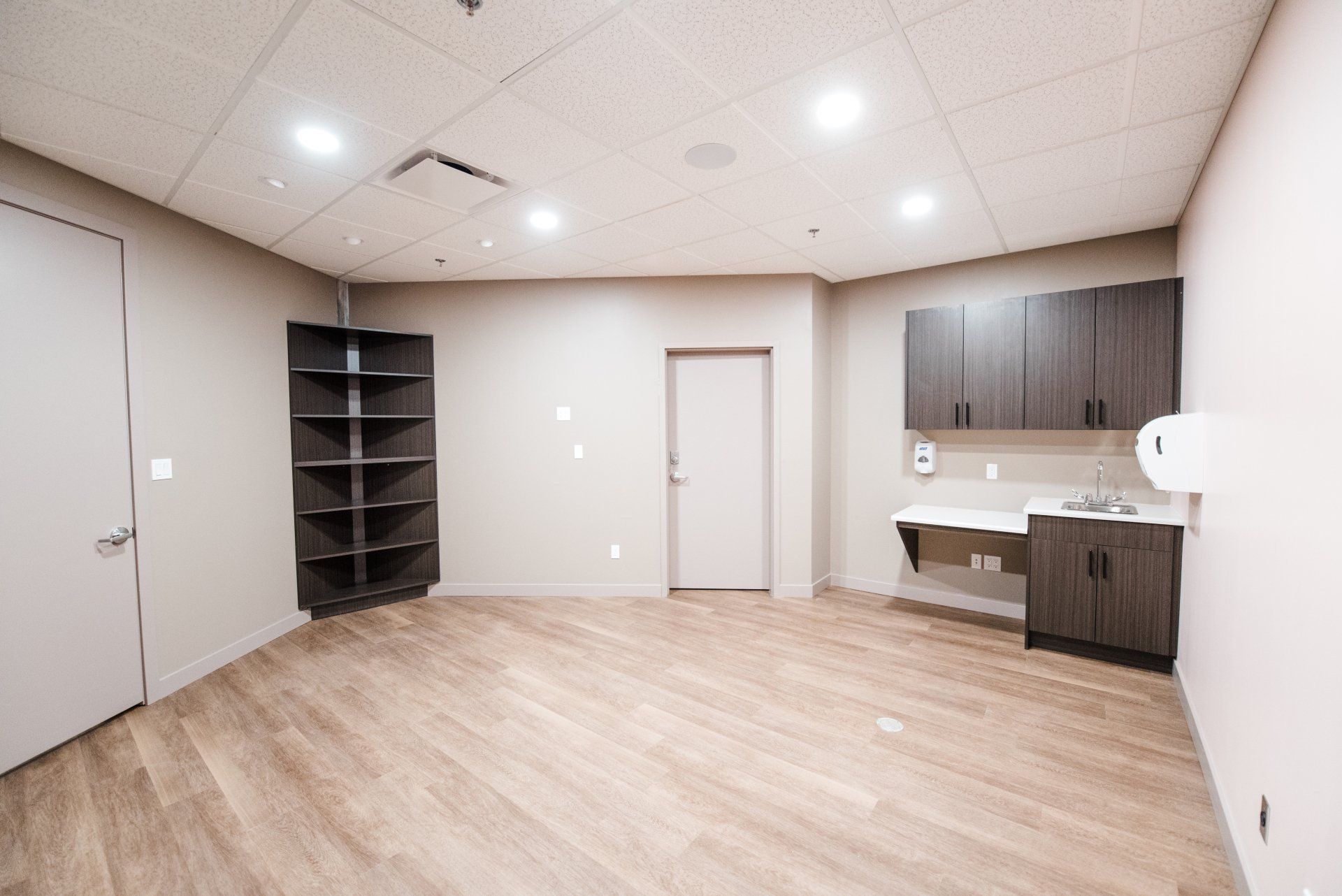 A large empty room with wooden floors and cabinets.