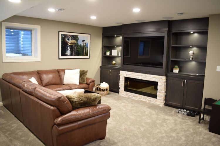 basement living room with fireplace and tv on wall