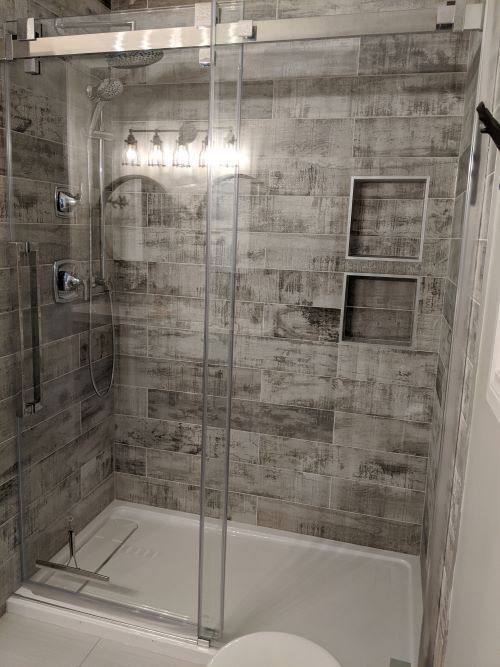 A bathroom with a sliding glass shower door and a toilet.