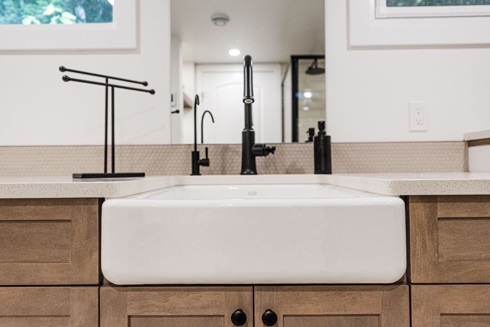 farm sink in bathroom with black faucet