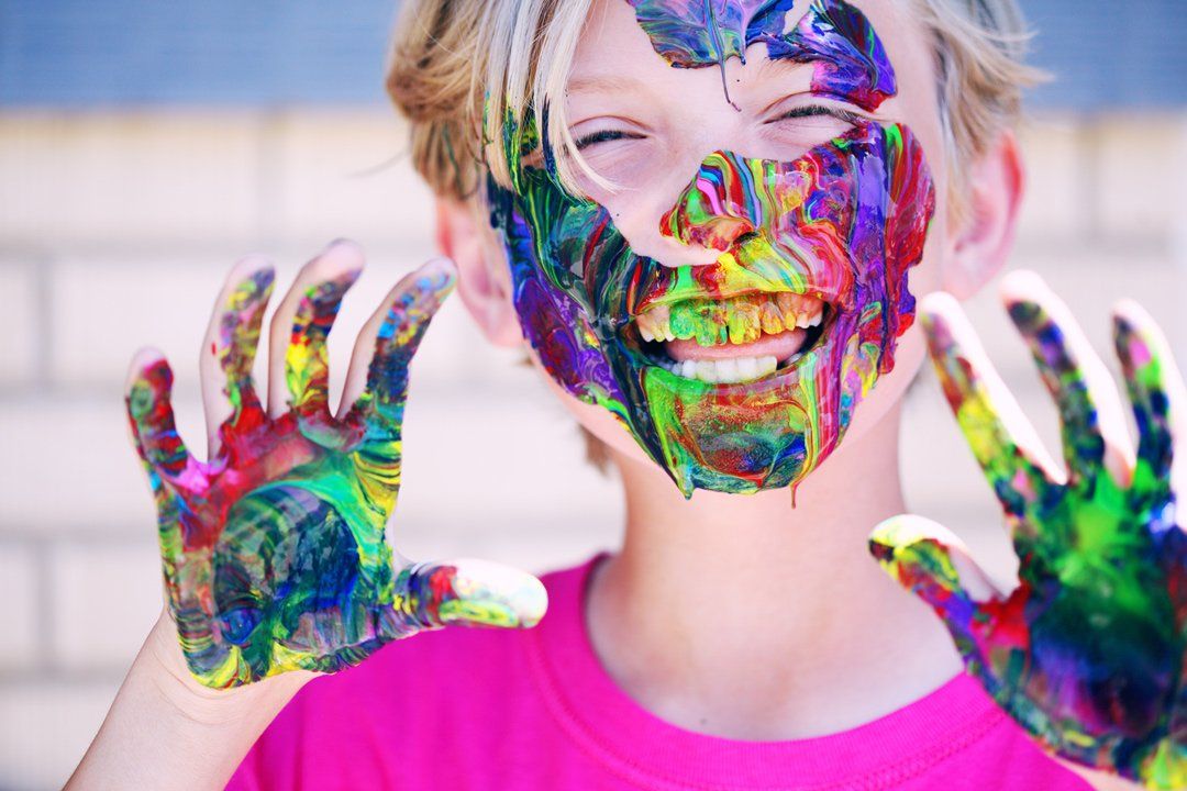 paint in a kids hand and face