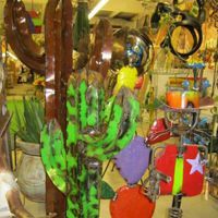 Colorful display of cacti, pottery, and hanging ornaments in a market or shop.