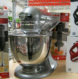 Chrome stand mixer on store display counter with bowl and attachments