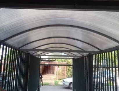 Uma varanda com teto transparente e corrimão branco.