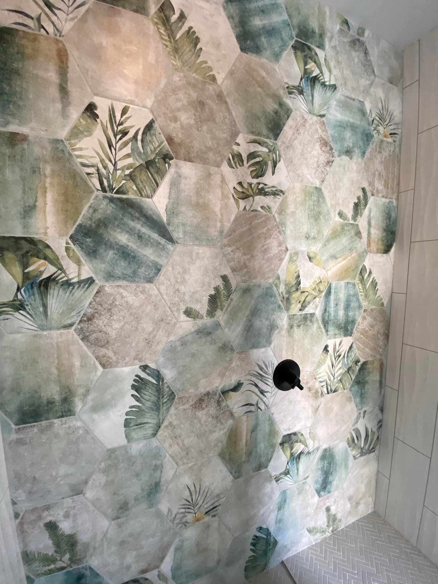 A shower with a floral pattern on the wall.