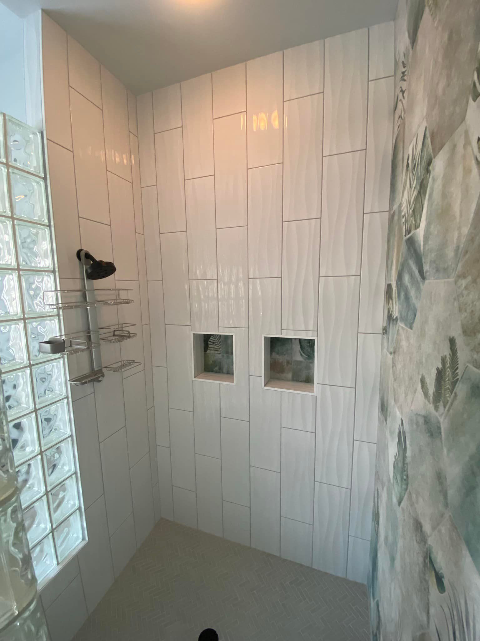A bathroom with white tiles and a walk in shower.