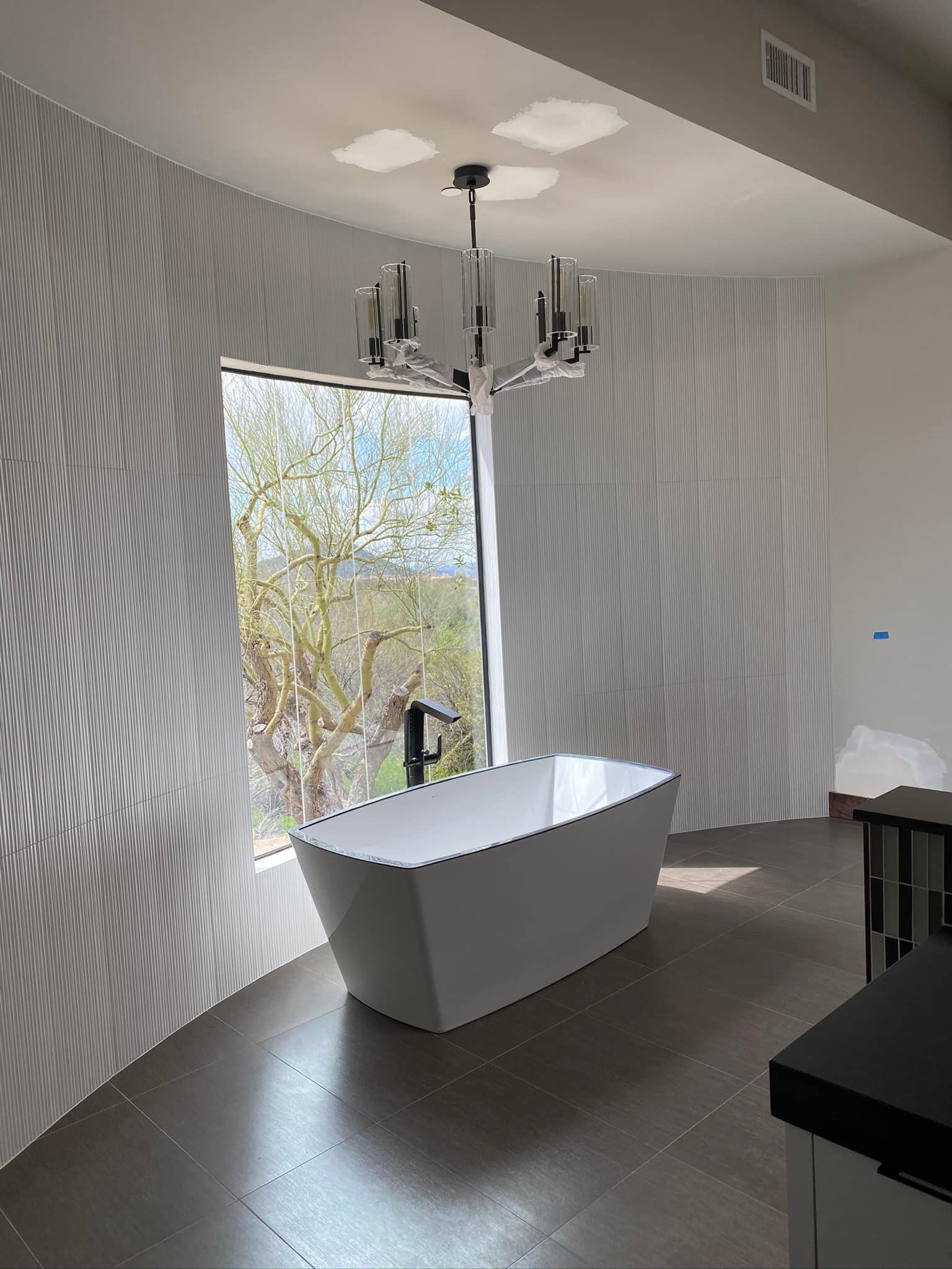 A bathroom with a bathtub and a window.