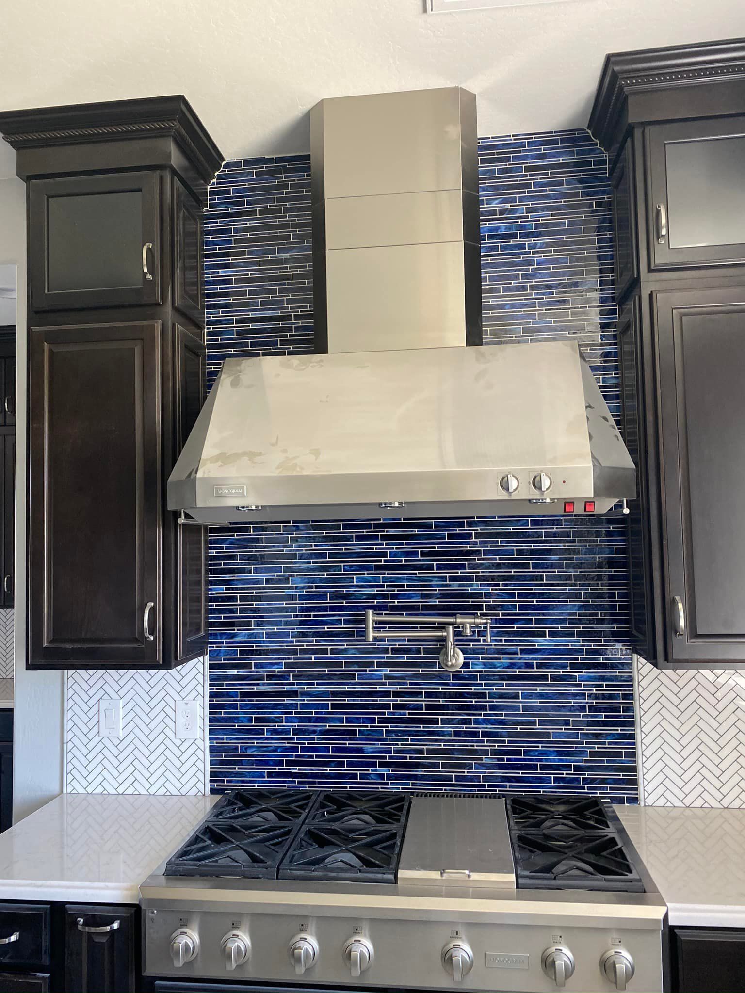 A kitchen with a stove top oven and a hood above it
