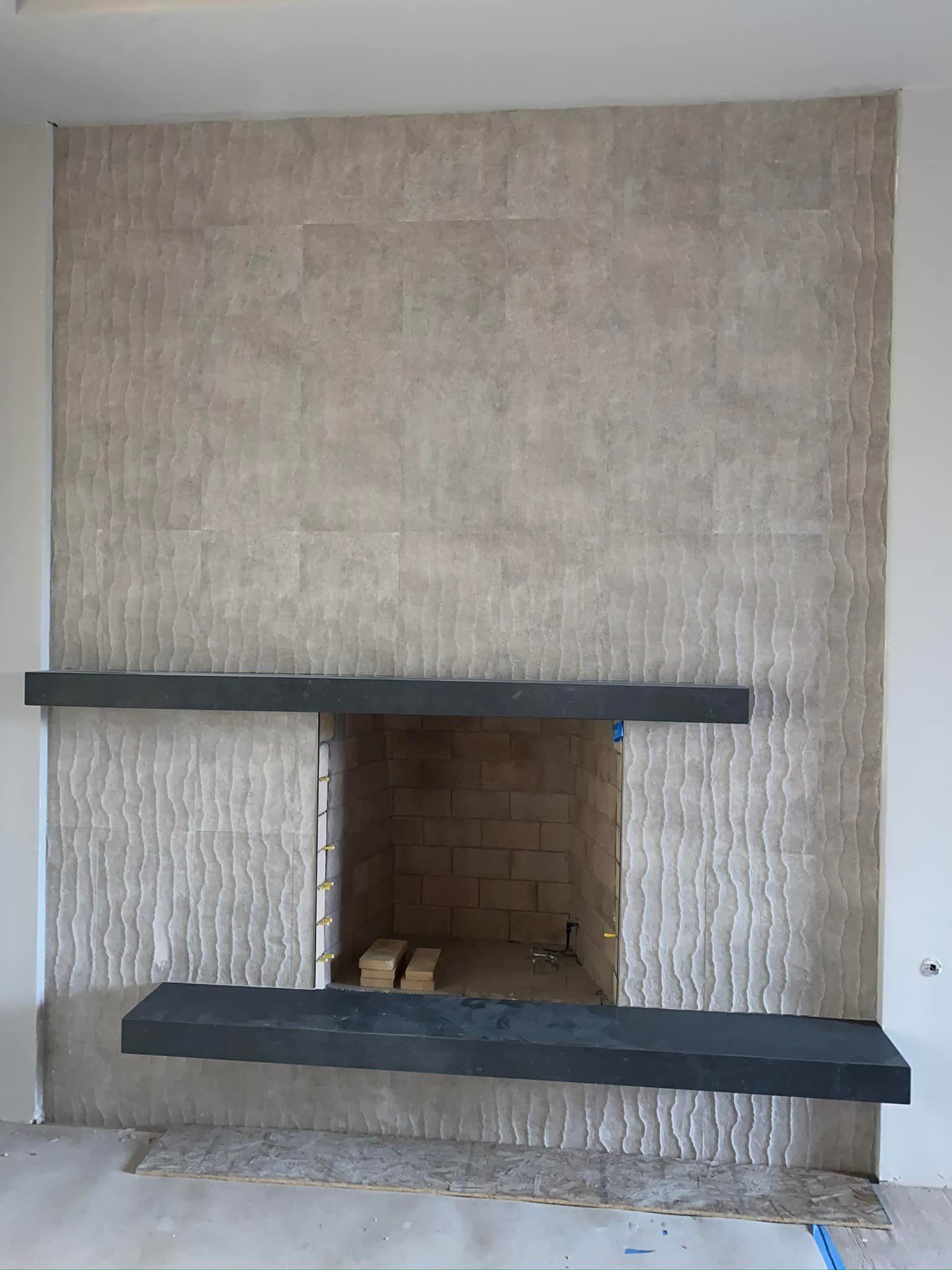 A fireplace with a black mantle in a living room.