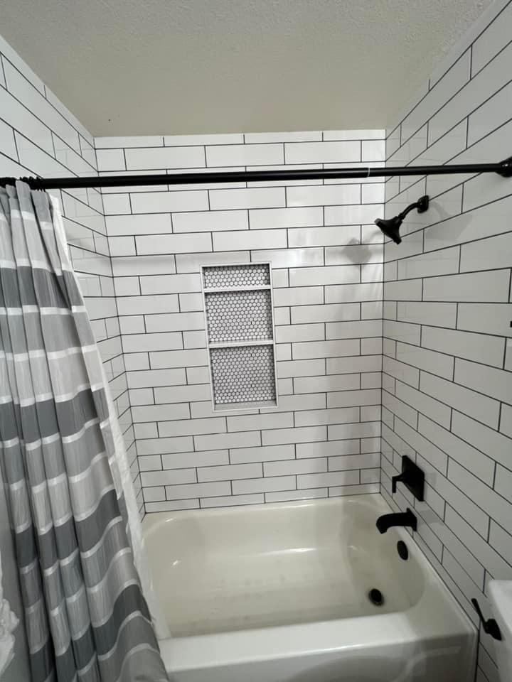 A bathroom with white brick walls and a bathtub.