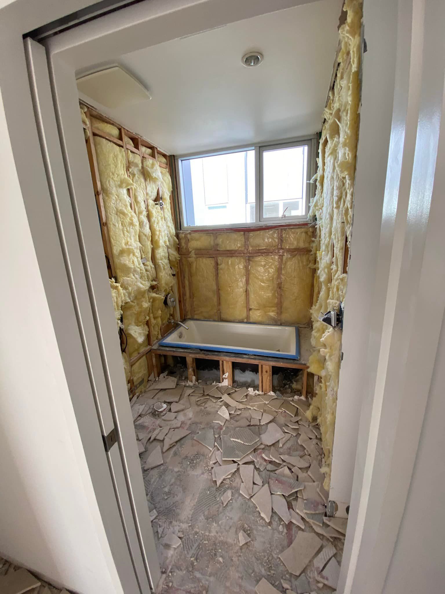 A bathroom under construction with a bathtub in it.