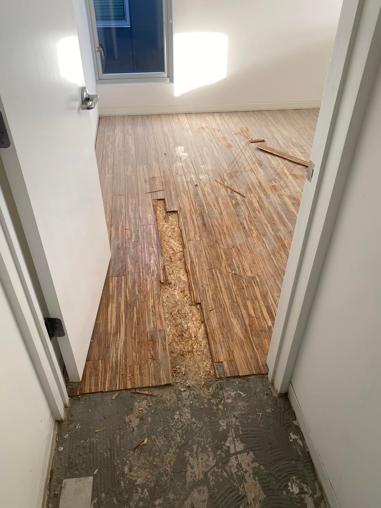 A room with a wooden floor and a door that is open.