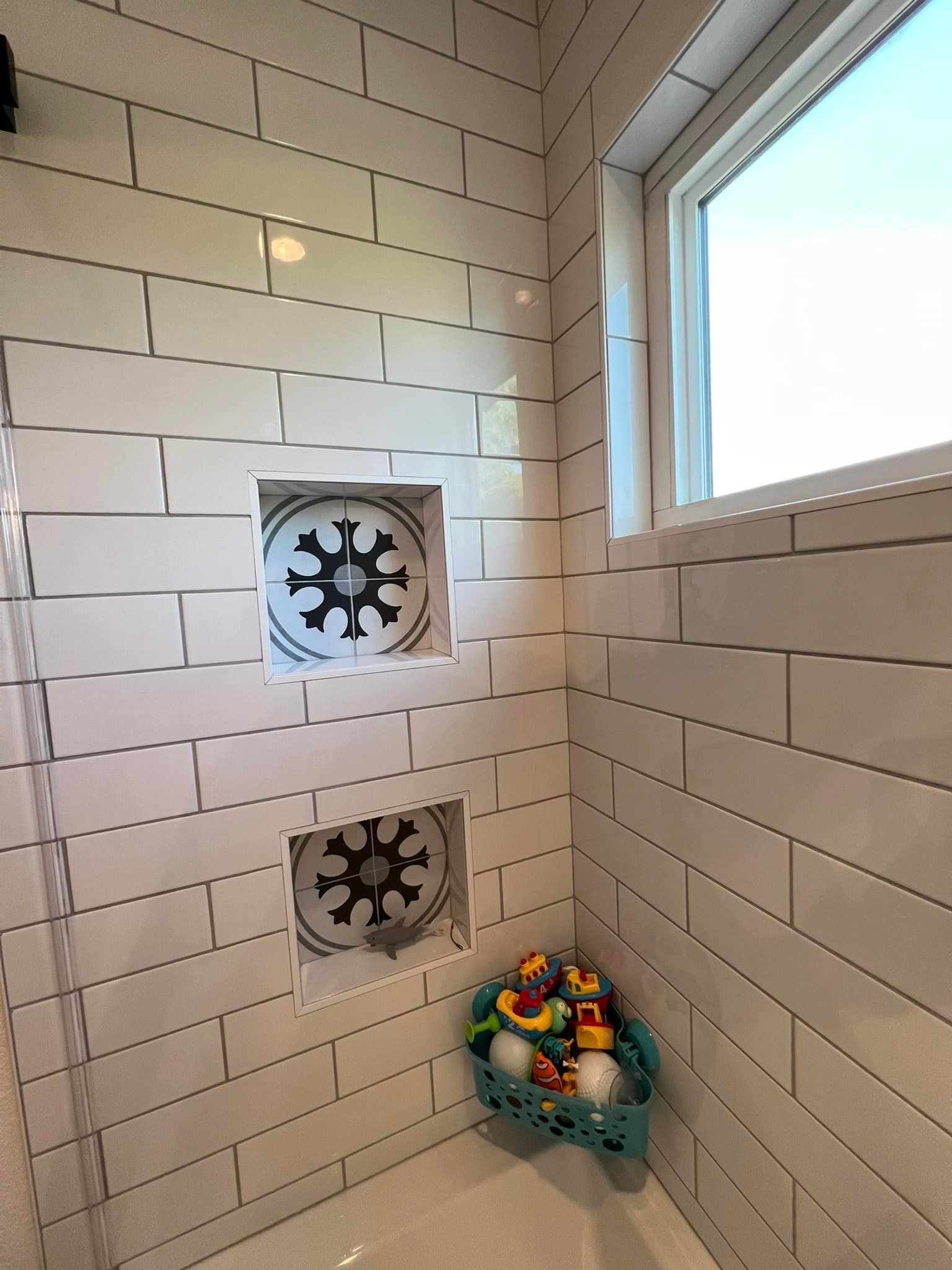 A bathroom with white brick walls and a window.