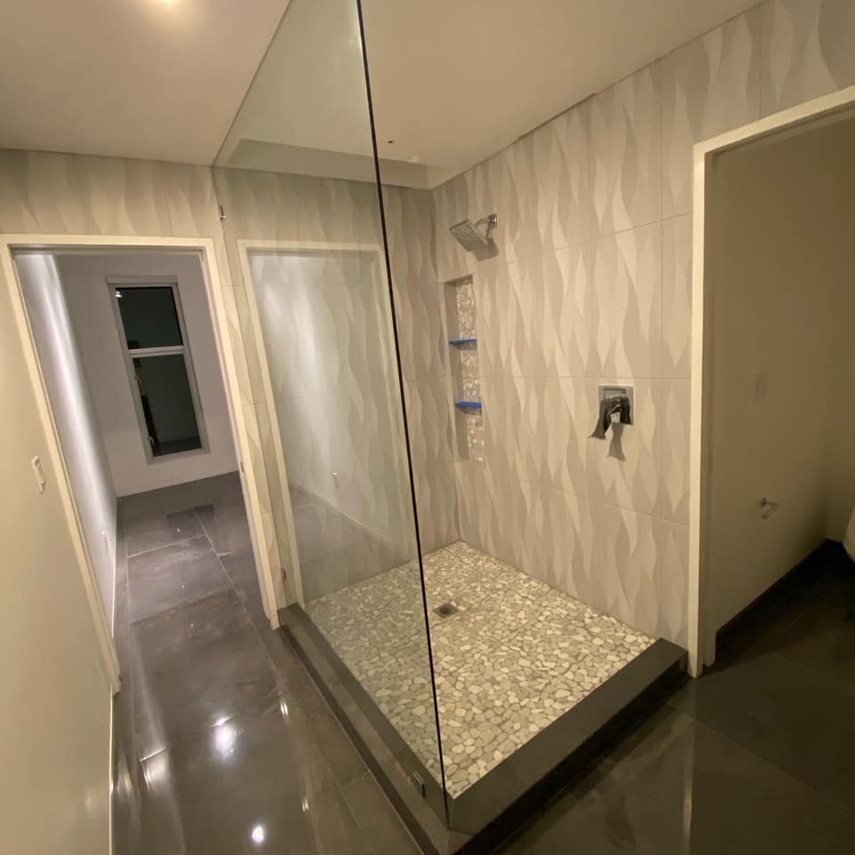 A bathroom with a walk in shower and a mirror.