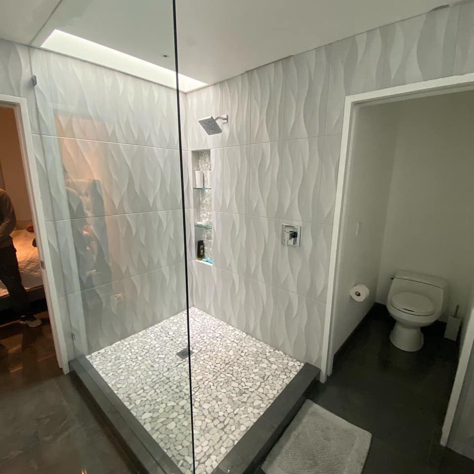 A bathroom with a walk in shower and a toilet.