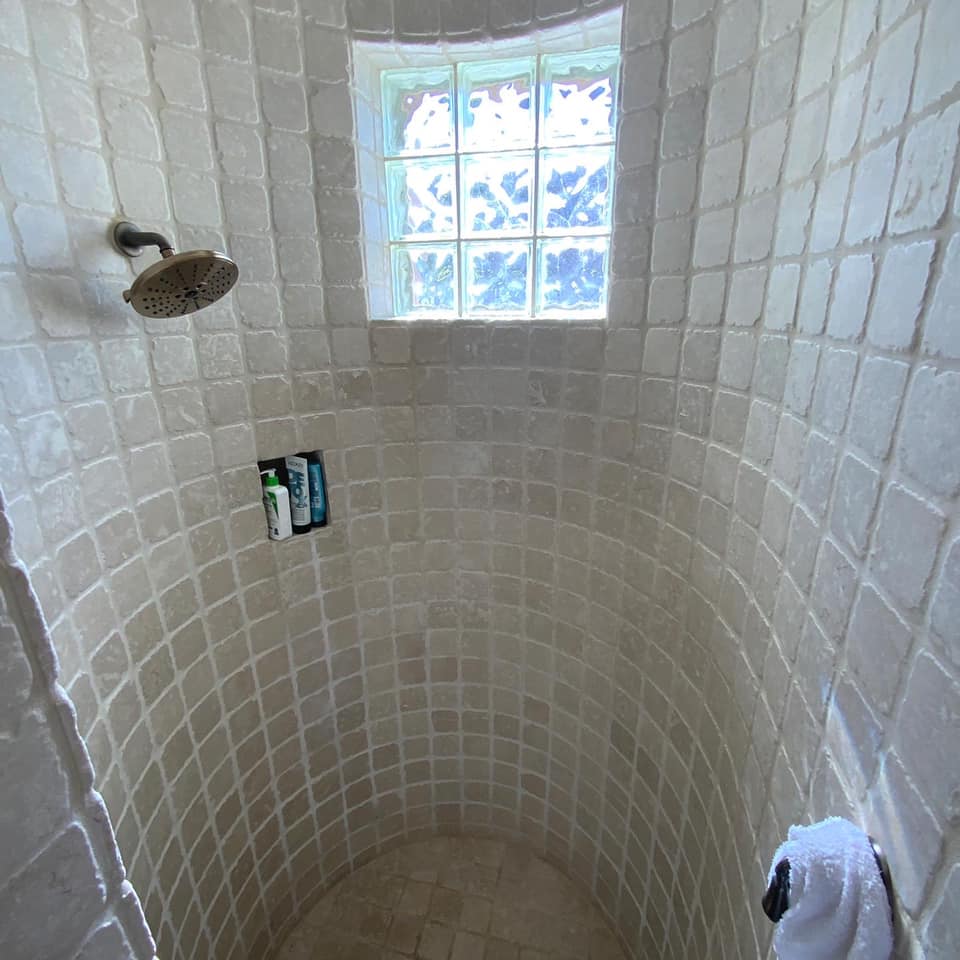A shower with a window and a shower head