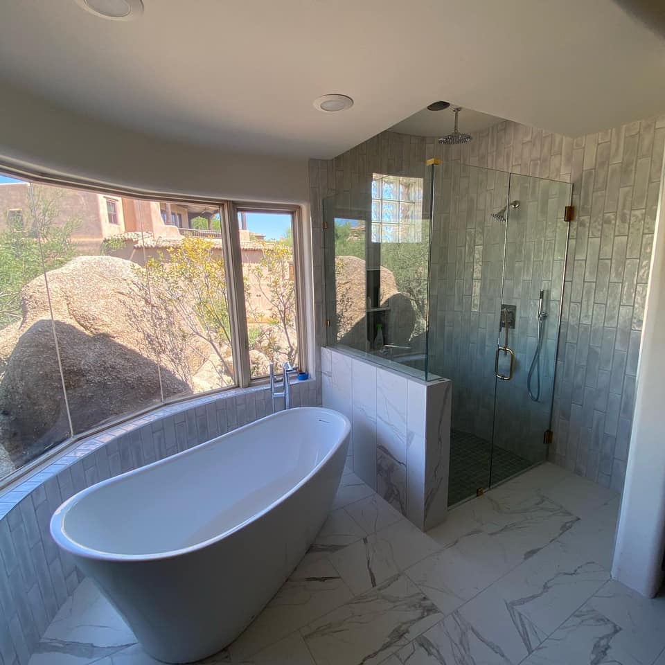 A bathroom with a bathtub and a walk in shower.