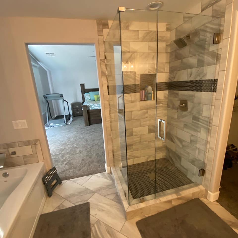 A bathroom with a walk in shower and a bathtub.