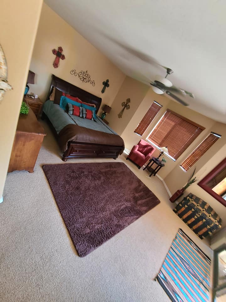 A bedroom with a king size bed and a rug