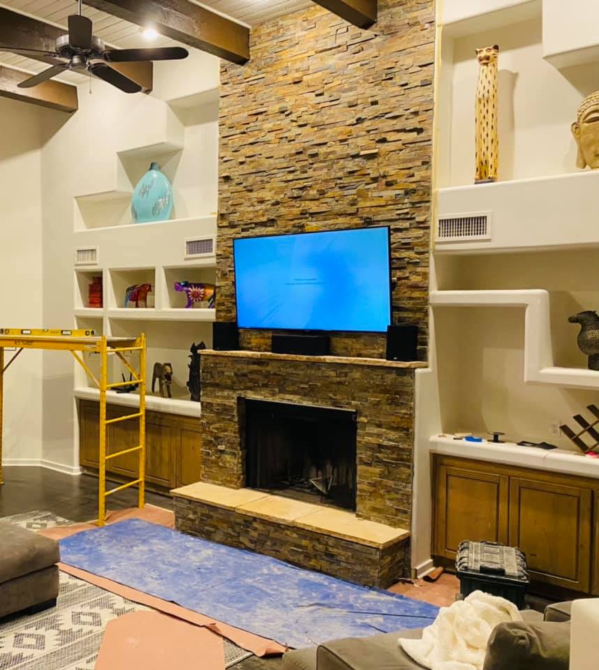 A living room with a fireplace and a flat screen tv