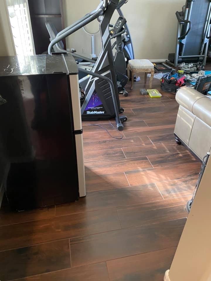 A living room with a treadmill and a refrigerator.