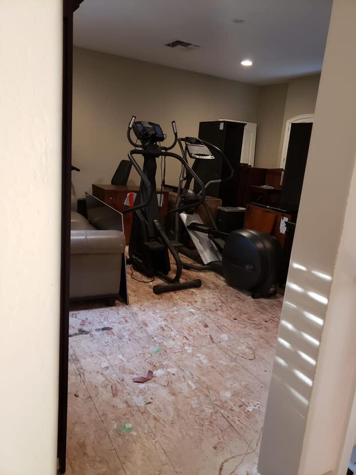 A room with a lot of furniture and a vacuum cleaner on the floor.