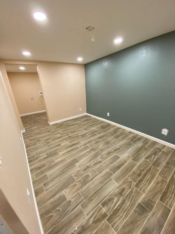 An empty room with a wooden floor and a blue wall.