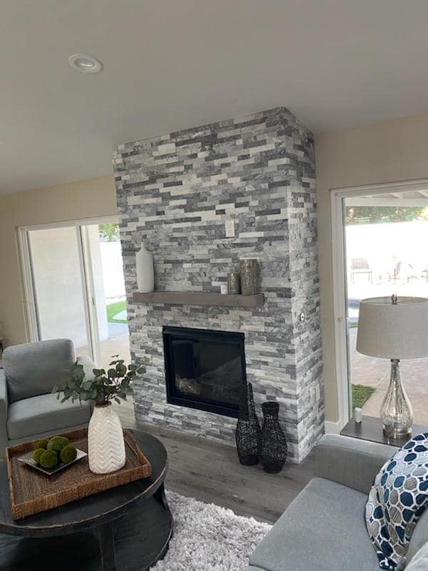 A living room with a fireplace , couch , chair and coffee table.