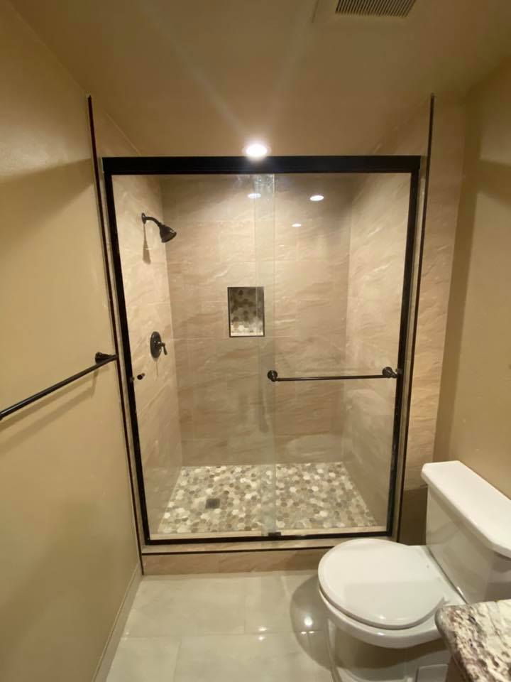 A bathroom with a toilet and a shower with a glass door.