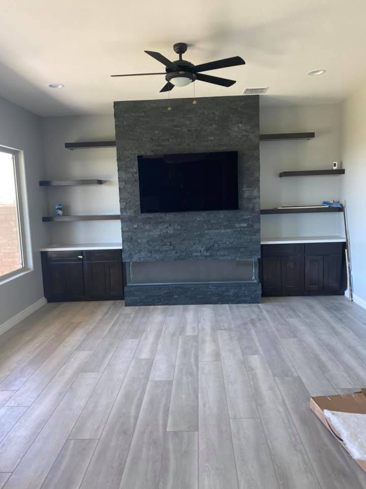 A living room with a fireplace and a flat screen tv on the wall.