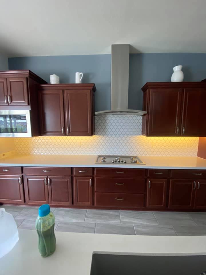 A kitchen with wooden cabinets and a stove top oven.