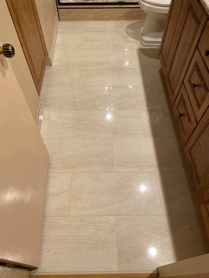 A bathroom with a white tile floor and a toilet.