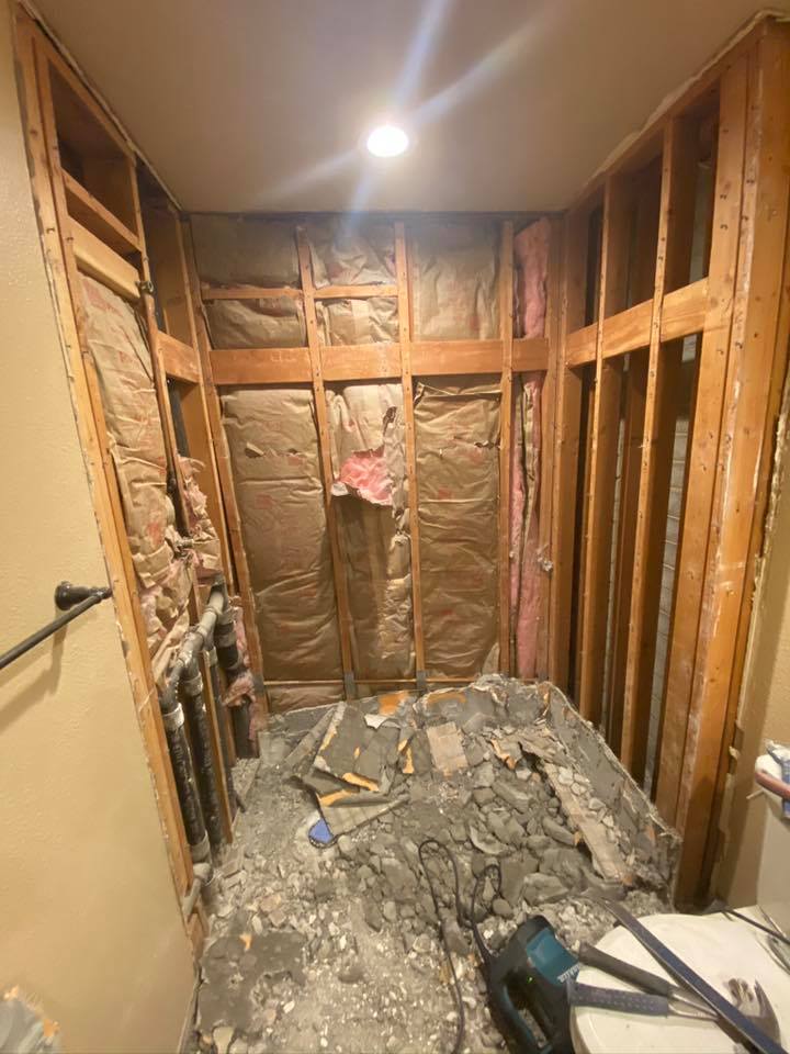 A bathroom under construction with wooden walls and a toilet.